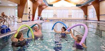 Residents enjoying water aerobics in the therapy pool