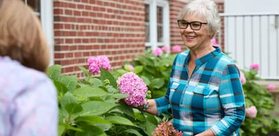 Senior resident enjoying flowers in the garden