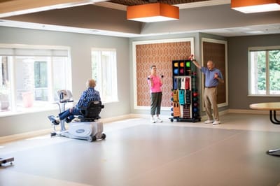 Residents engaged in group exercise activities in a fitness room