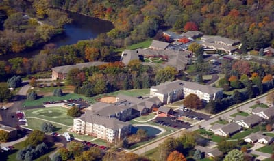 Aerial view of a senior living campus surrounded by trees