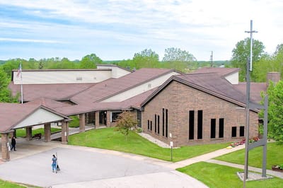 Exterior view of a senior living facility with a cross