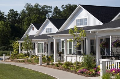 Walking path leading to residential cottages with gardens
