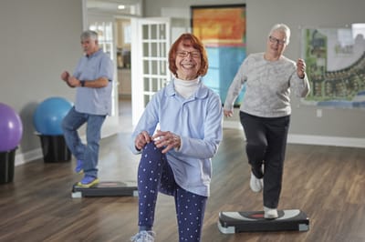 Residents participating in an exercise class in a bright activity room