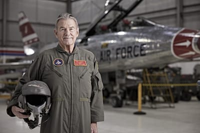 Senior veteran posing with an aircraft in a hangar
