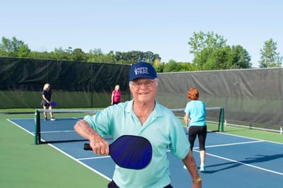 Residents playing pickleball on an outdoor court
