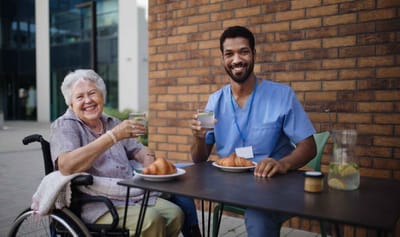 Staff and resident enjoying a meal outdoors