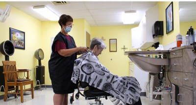 A resident receiving a haircut in the salon