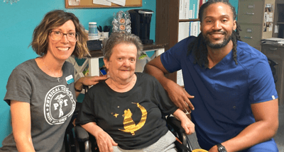 Staff member and resident smiling together in a hallway