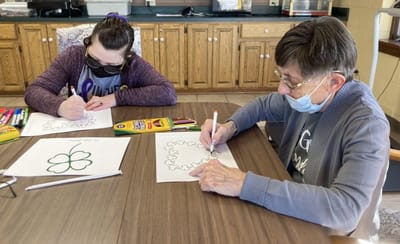 Residents engaging in a coloring activity at a table