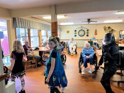 Residents and children celebrating an event in the activity room