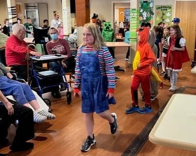 Residents enjoying a performance by children during an event