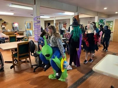 Residents and staff in costumes during a festive activity