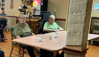 Two residents seated at a table in a common area