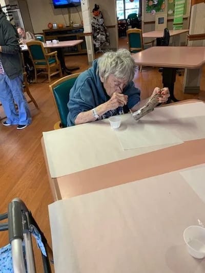 Resident engaged in an activity at a dining table
