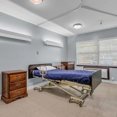 Private resident room with a hospital bed and dresser