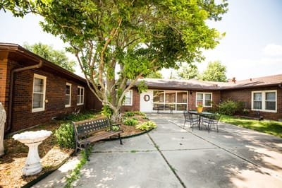 Outdoor patio area with benches and landscaping