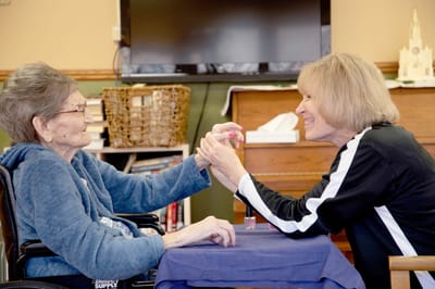 Resident and staff member enjoying nail painting activity
