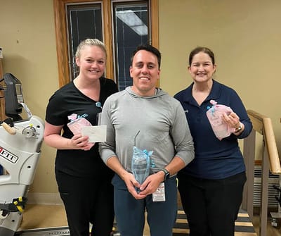 Staff member celebrating with resident in therapy area