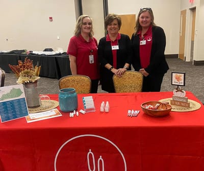 Staff members at an information table with decorations