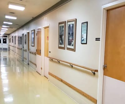 A corridor in a senior living facility with framed pictures