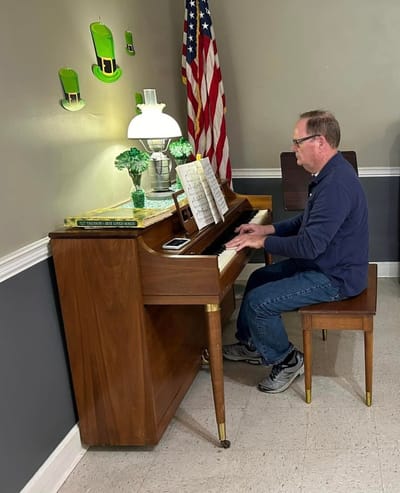 Resident enjoying music at a piano in a common area