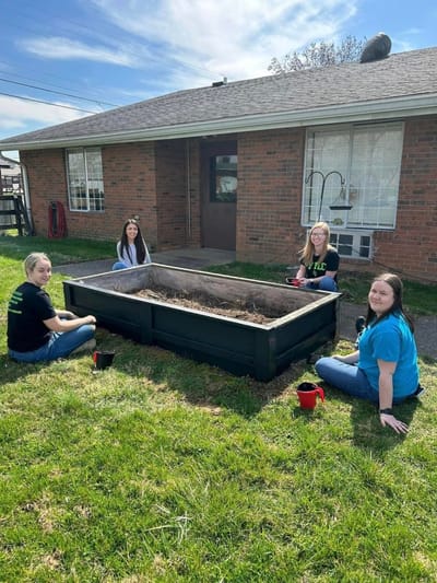 Residents gardening in an outdoor raised bed area