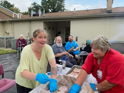 Residents and staff enjoying a barbeque activity outside