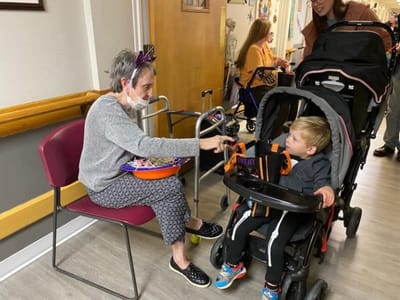 Resident interacting with a child in a hallway