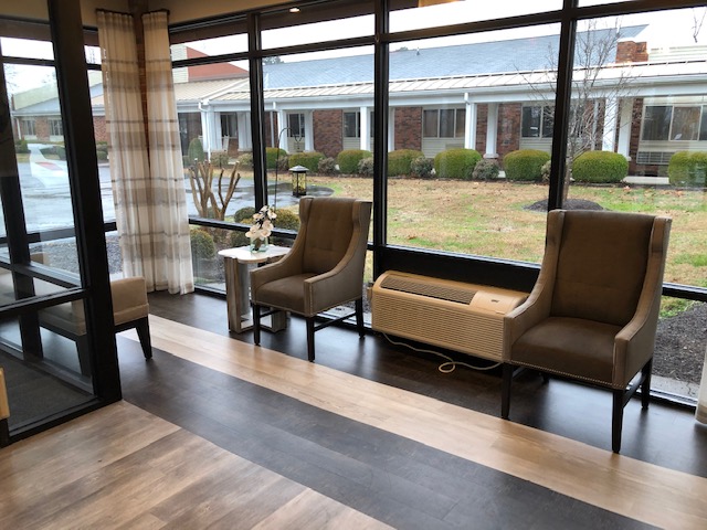 Sunlit common area with seating overlooking the garden