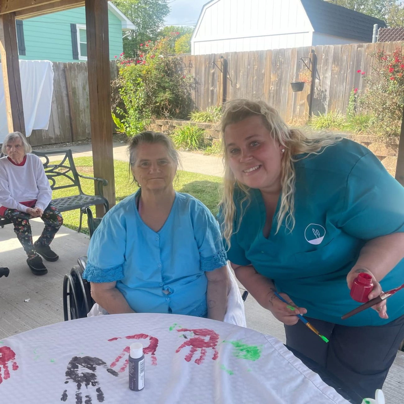 Residents engaging in a handprint art activity outdoors