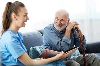 Senior man smiling and talking with a caregiver