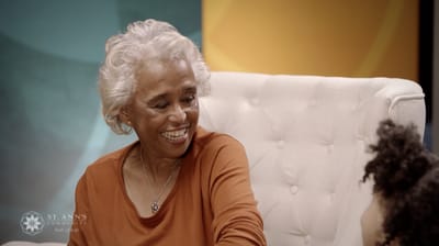 Senior woman smiling while speaking with a caregiver