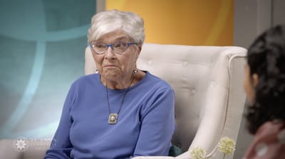 An elderly woman listening attentively in a cozy setting