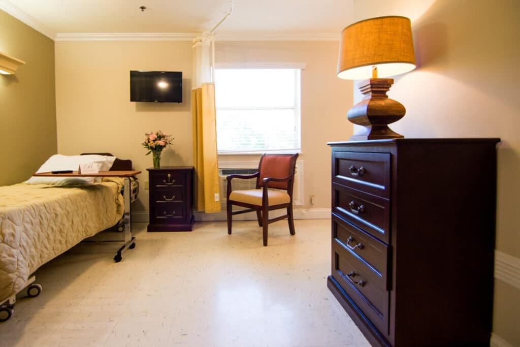 Cozy private resident room with a bed and chair