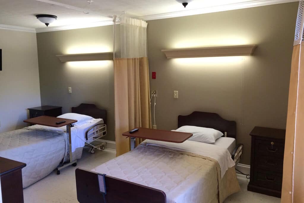 Two private resident rooms with beds and bedside tables