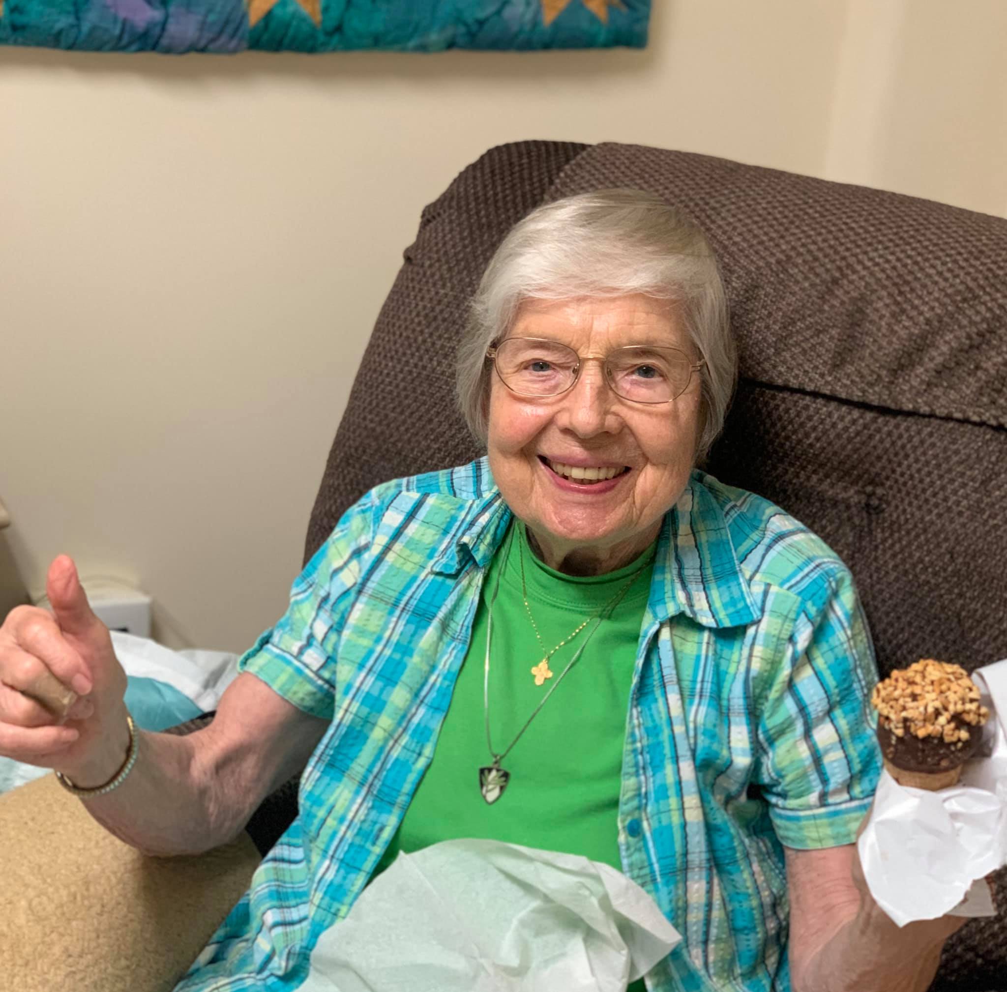 Resident enjoying a treat in a cozy chair