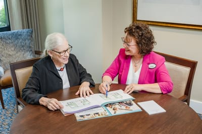 Resident and staff discussing in an interior space