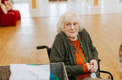 Senior woman in a wheelchair smiling in a common area