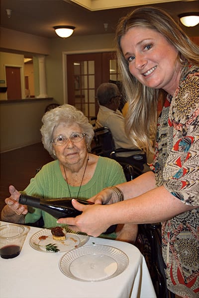 Resident enjoying a meal with a staff member