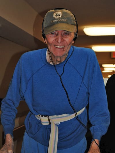 Smiling resident in a blue sweater with headphones