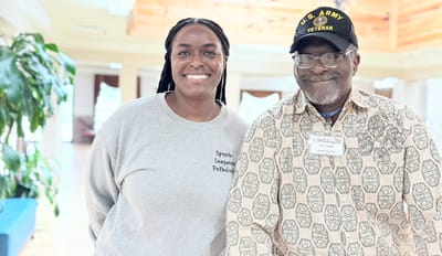 A staff member and a resident smiling together in a facility
