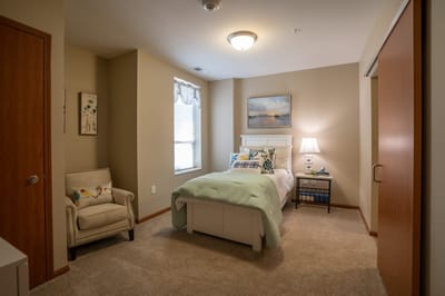 Cozy resident room with a bed and armchair