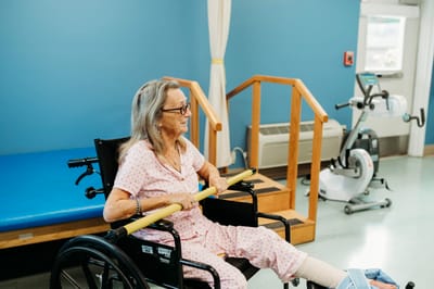 A senior woman exercising in a therapy room