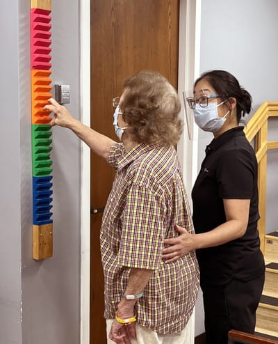 A resident interacting with staff in an activity