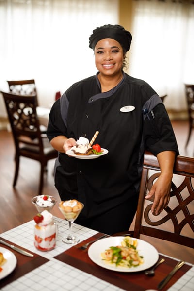 Chef presenting desserts in a dining room