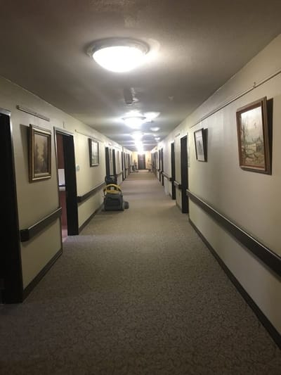 Long hallway with artwork and vacuum cleaner