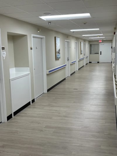 A well-lit corridor with doors and artwork