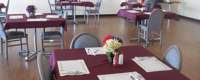 A dining room set up for meals with tables and chairs