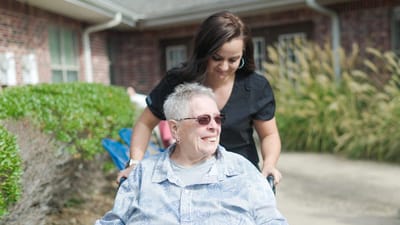 Staff member assisting a resident outdoors