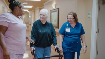 Staff assisting a resident in a hallway